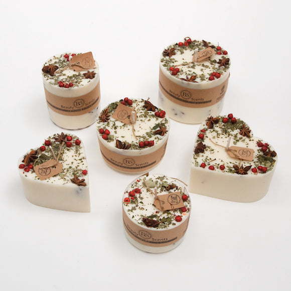 Kerzen mit Sternanis und roten Beeren